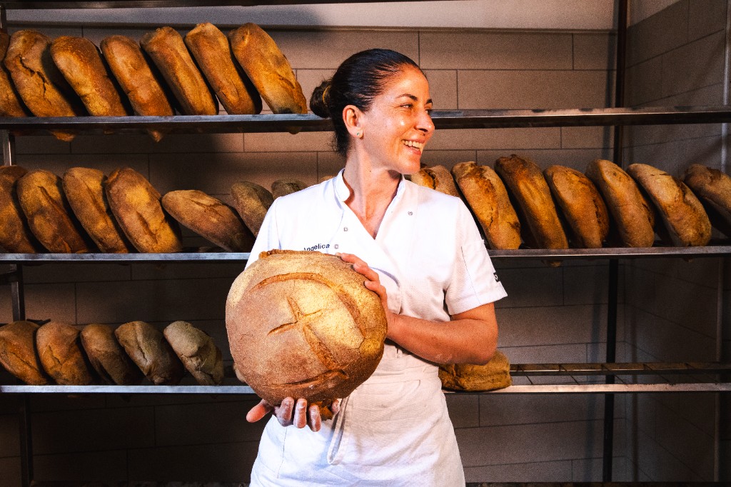 Angelica con pane fresco davanti alle graticce del forno